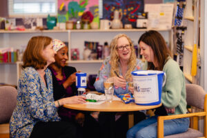 Four women sat at a table laughing